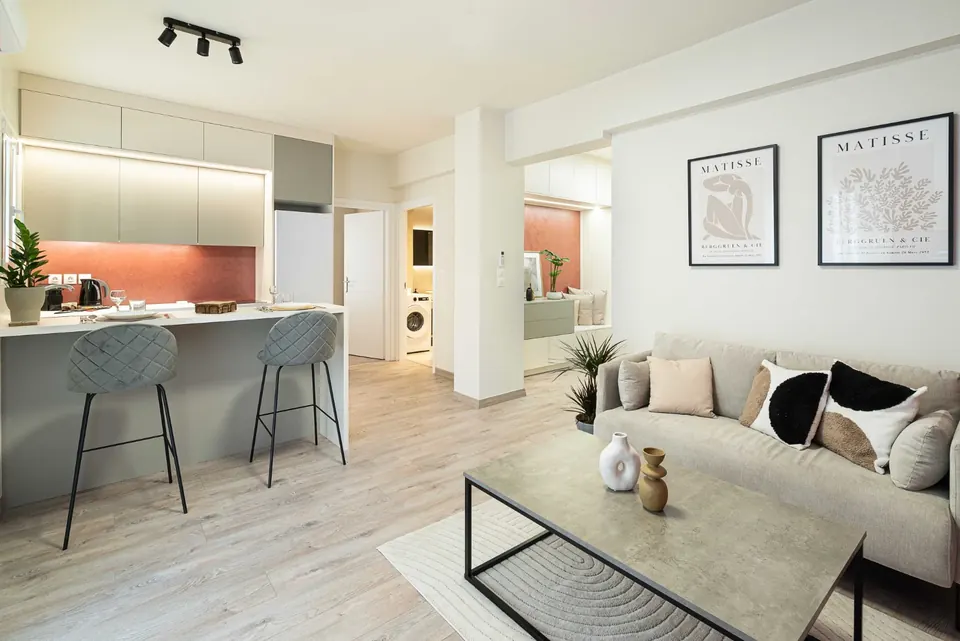 אי מטבח עם כיסאות בר ופינת ישיבה, דירת Airbnb באתונה